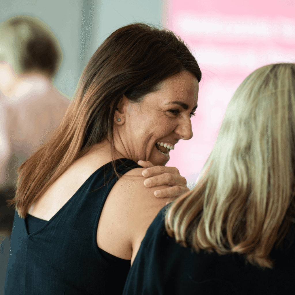 Natalie sitting down side on laughing