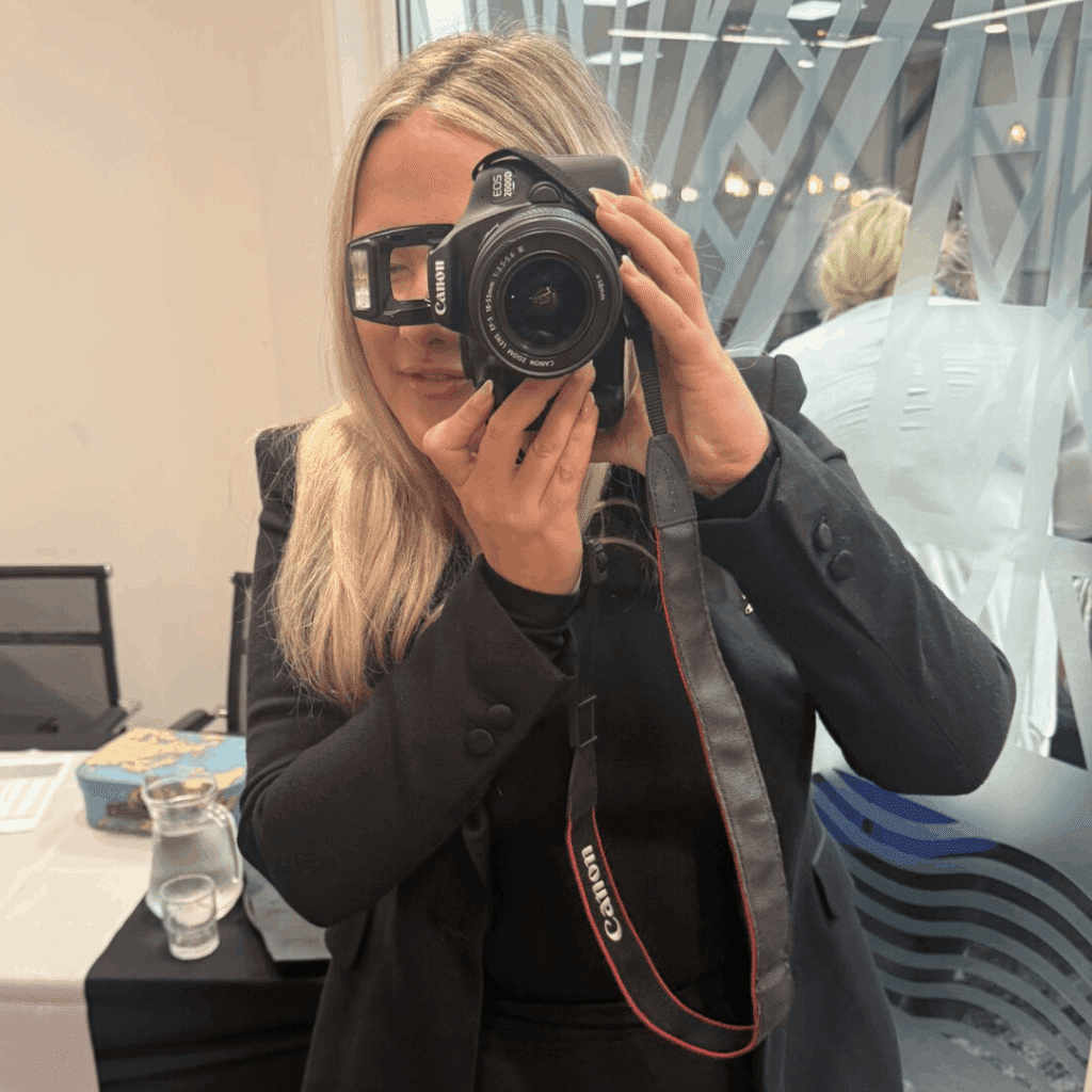 Georgia holding and pointing a camera