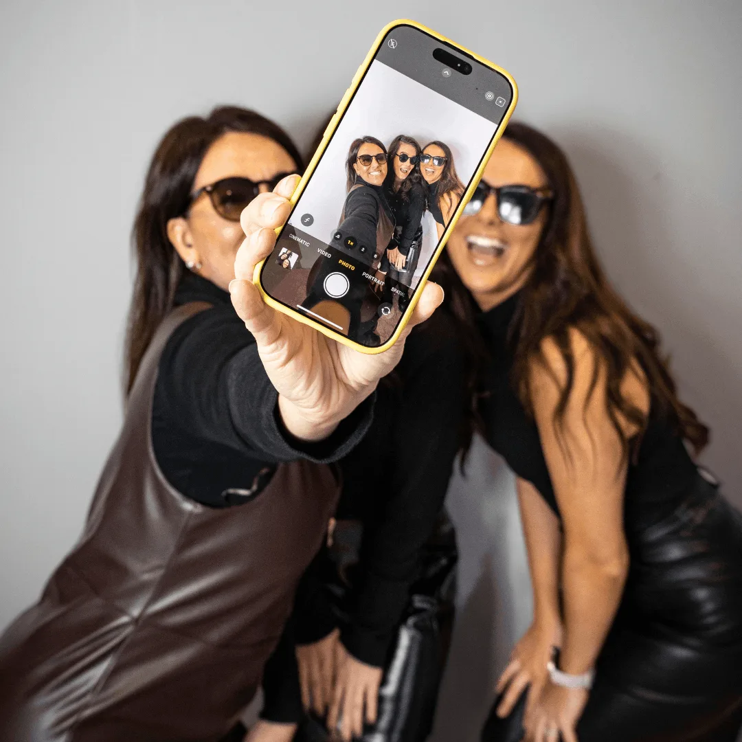 Creative Collins team with Natalie holding out a mobile phone with the screen in full view