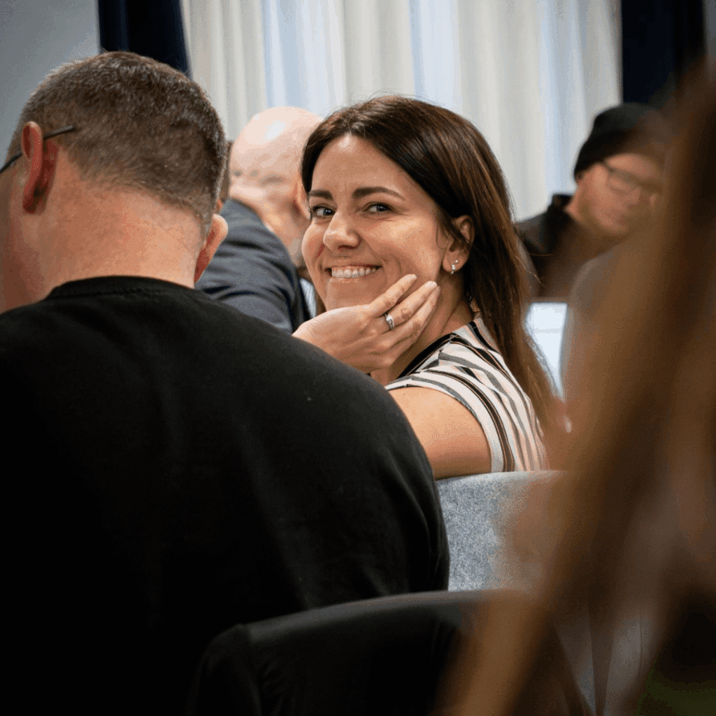 Natalie sitting at an event facing sideways with a smile